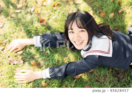 芝生で寝そべる女子高生 95628457