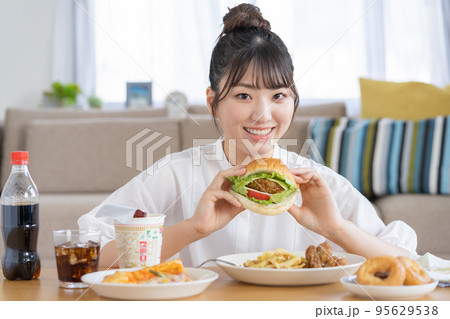 チートデイ　ハンバーガーを手に微笑む若い女性 95629538