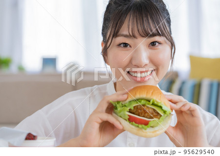 チートデイ　ハンバーガーを手に微笑む若い女性 95629540