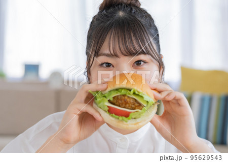 チートデイ　ハンバーガーを微笑む若い女性 95629543