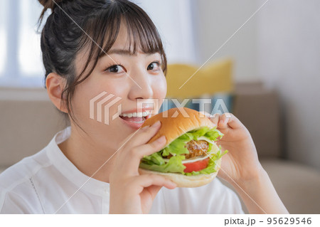 チートデイ　ジャンクフードを前に微笑む若い女性 95629546