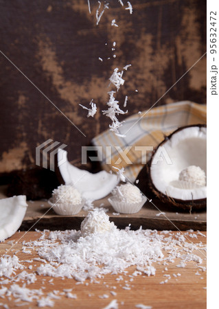 Close up of white candies and coconut with white pulp, coconut chip on wooden background.. Close up of white candies and coconut with white pulp, coconut chip on wooden background.. 95632472