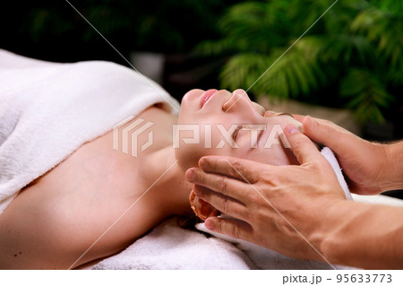 Close-up of a beautiful woman receiving a soothing head massage. Close-up of a beautiful woman receiving a soothing head massage. 95633773