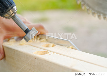 Crpenter builder working overall equals a wooden bar with a milling machine in the workshop Crpenter builder working overall equals a wooden bar with a milling machine in the workshop 95633929