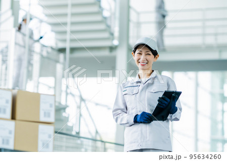 タブレット端末を持ち出荷検査をするスタッフ 95634260