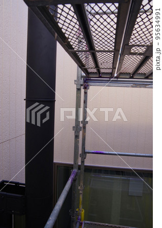 戸建て住宅の外壁塗装　屋根塗装　現場　足場の組まれた家　塗装工事　足場　住宅工事の様子　養生 95634991