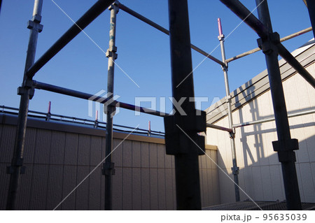戸建て住宅の外壁塗装　屋根塗装　現場　足場の組まれた家　塗装工事　足場　住宅工事の様子　養生 95635039