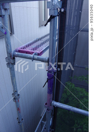 戸建て住宅の外壁塗装　屋根塗装　現場　足場の組まれた家　塗装工事　足場　住宅工事の様子　養生 95635040