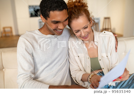 Two young people sitting on the sofa and choosing something online 95635340