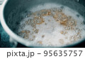 Boiling oatmeal porridge in a pan, close-up shot 95635757