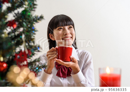 クリスマスを楽しみに待つ女子高校生 マグカップで飲み物を飲んで温まる クリスマスを楽しみに待つ女子高校生 マグカップで飲み物を飲んで温まる 95636335