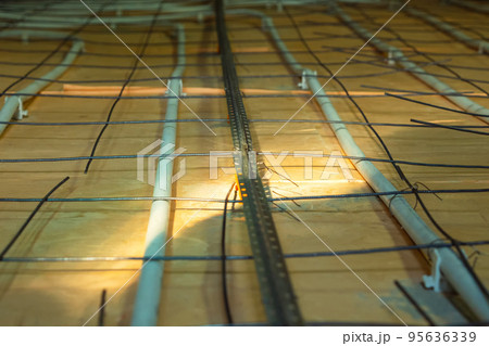 Floor heating system in a private home. In close-up. Mounting the floor heating. Preparing to pour concrete floor. Selective focus. Floor heating system in a private home. In close-up. Mounting the floor heating. Preparing to pour concrete floor. Selective focus. 95636339