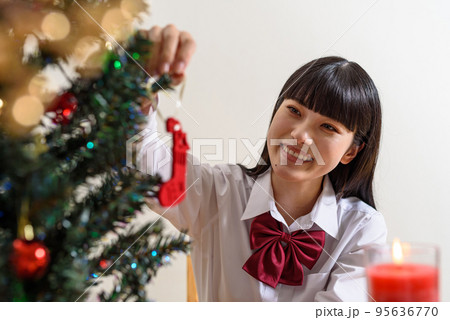 クリスマスを楽しみに待つ女子高校生 クリスマスツリーの飾り付けをしながら クリスマスを楽しみに待つ女子高校生 クリスマスツリーの飾り付けをしながら 95636770