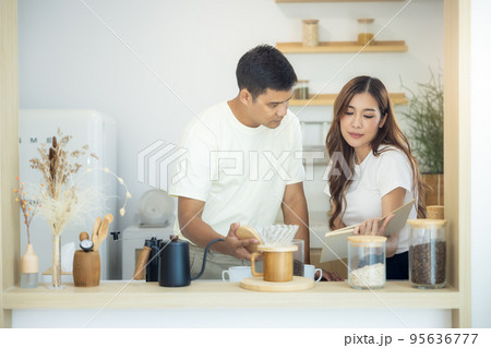 Couple to make, brew or drink coffee in kitchen home. 95636777