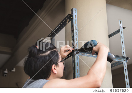 do it yourself concept, Craftsmen use electric drills to assemble old iron parts. Make a shelf on your free weekend. do it yourself concept, Craftsmen use electric drills to assemble old iron parts. Make a shelf on your free weekend. 95637620