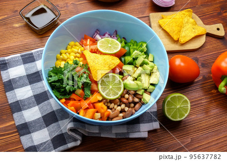 Cowboy caviar is traditional mexican vegetable salad. Corn, beans, tomatoes, peppers, onions lime avocado 95637782