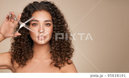 Beautiful young woman with a scissors 95638191