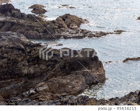 Exposed rocks on the shore. Seaside in sunny weather, rock formation near body of water. Exposed rocks on the shore. Seaside in sunny weather, rock formation near body of water. 95638215