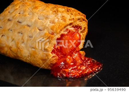 One baked bun with red strawberry jam in electric oven: close up One baked bun with red strawberry jam in electric oven: close up 95639490