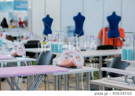 Tailor, fashion designer workplace - sewing machine, ironing board at atelier 95639550