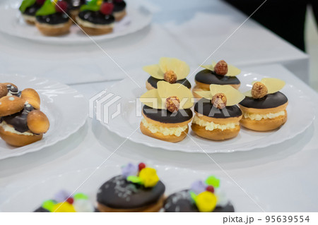 Fresh shortcrust tart cakes with cream and fruits on white plate for sale 95639554