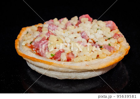Uncooked homemade mini pizza on tray on tray in electric oven, black background 95639581