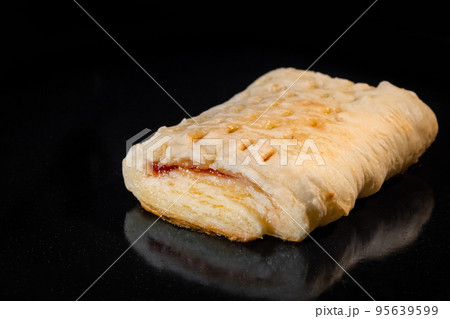 Bun with red strawberry jam baking in electric oven: close up 95639599