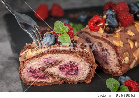 Meringue roll with raspberry berries, pigeons and mint leaves 95639963