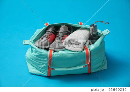 Sports bag with gym stuff on blue background Sports bag with gym stuff on blue background 95640252