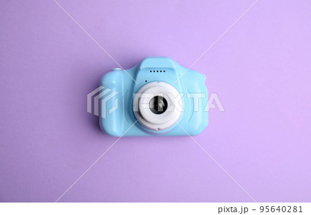 Light blue toy camera on violet background, top view. Future photographer Light blue toy camera on violet background, top view. Future photographer 95640281