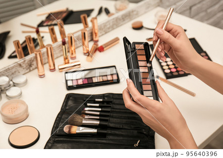 Professional makeup artist with eyeshadow palette 95640396