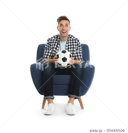 Handsome young man sitting in armchair and watching soccer match on white background 95640506