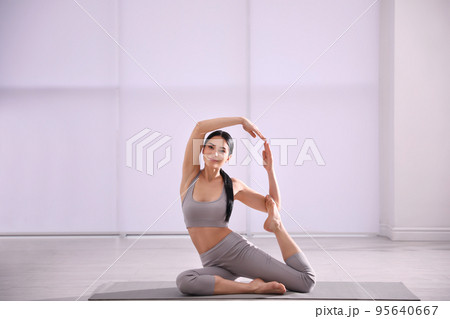 Young woman practicing mermaid asana in yoga studio. Eka Pada Rajakapotasana pose 95640667
