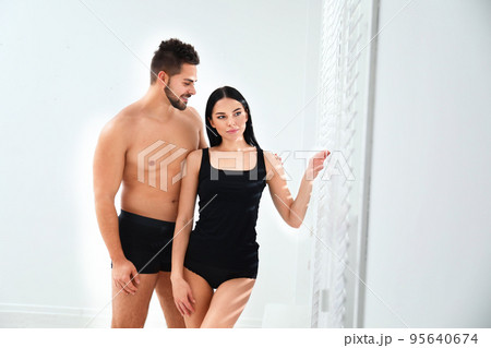 Young couple in black underwear near window indoors Young couple in black underwear near window indoors 95640674