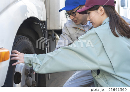 トラックのタイヤを点検する男女のドライバー トラックのタイヤを点検する男女のドライバー 95641560