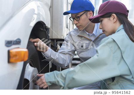 トラックのタイヤを点検する男女のドライバー トラックのタイヤを点検する男女のドライバー 95641562