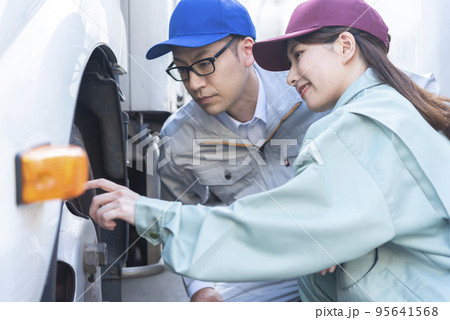 トラックのタイヤを点検する男女のドライバー トラックのタイヤを点検する男女のドライバー 95641568