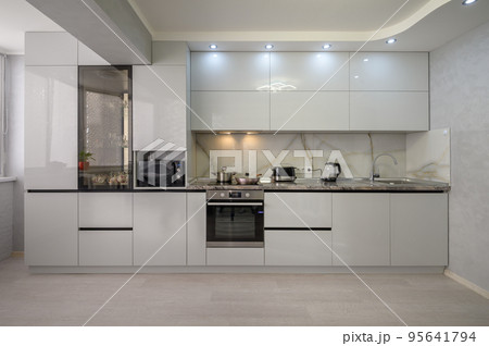 Interior of modern trendy white kitchen, front view Interior of modern trendy white kitchen, front view 95641794