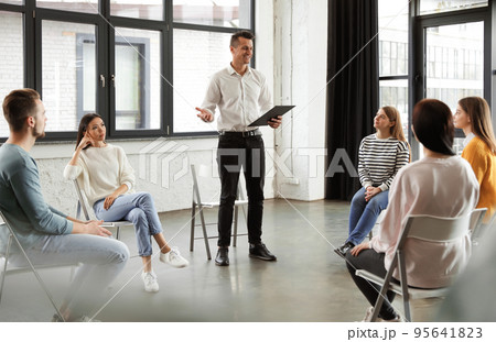Psychotherapist working with patients in group therapy session indoors Psychotherapist working with patients in group therapy session indoors 95641823