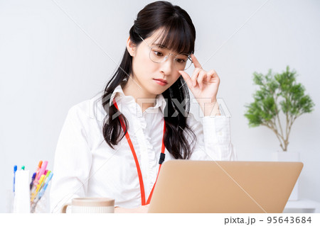 オフィスでノートパソコンを使う眼鏡の若い女性 95643684