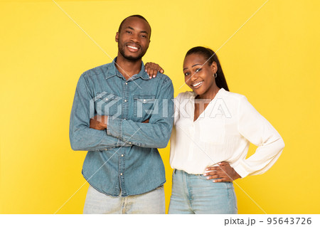 Cheerful Black Couple Posing Together Over Yellow Background Cheerful Black Couple Posing Together Over Yellow Background 95643726