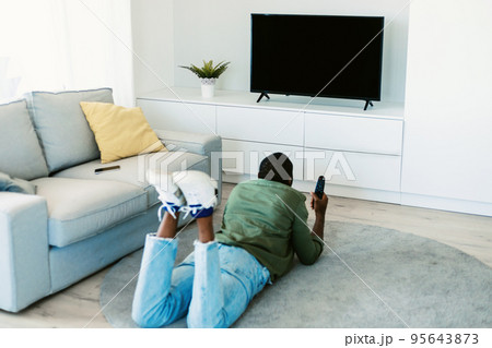 Sports and movies at home. Unrecognizable african american guy watching TV with empty screen in living room, mockup Sports and movies at home. Unrecognizable african american guy watching TV with empty screen in living room, mockup 95643873