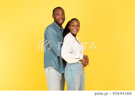 Loving Black Couple Embracing Posing Standing Over Yellow Background Loving Black Couple Embracing Posing Standing Over Yellow Background 95644166