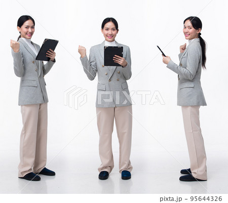Full Length 20s Asian Woman wear formal business blazer suit  dress pant shoes. Black long straight hair female hold tablet work confident, walking forward turn left right, white background isolated 95644326