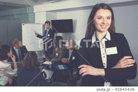 business woman in meeting room with working group behind 95645426