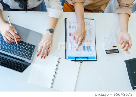 Negotiation, Analysis, Discussion, Asian woman economist and marketer pointing to a financial data sheet to plan investments to prevent risks and losses for the company. 95645675