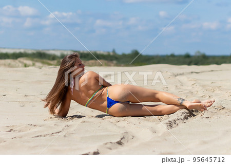 Slim woman resting on sandy beach 95645712