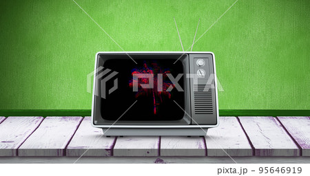 Composite of palm tree in television set over wooden table against green background, copy space 95646919