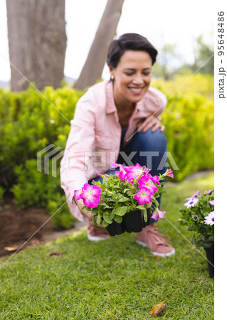 Vertical portrait of caucasian women spending time in the garden, planting Vertical portrait of caucasian women spending time in the garden, planting 95648486