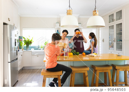 Caucasian family unpacking shopping bag together in the modern kitchen 95648503